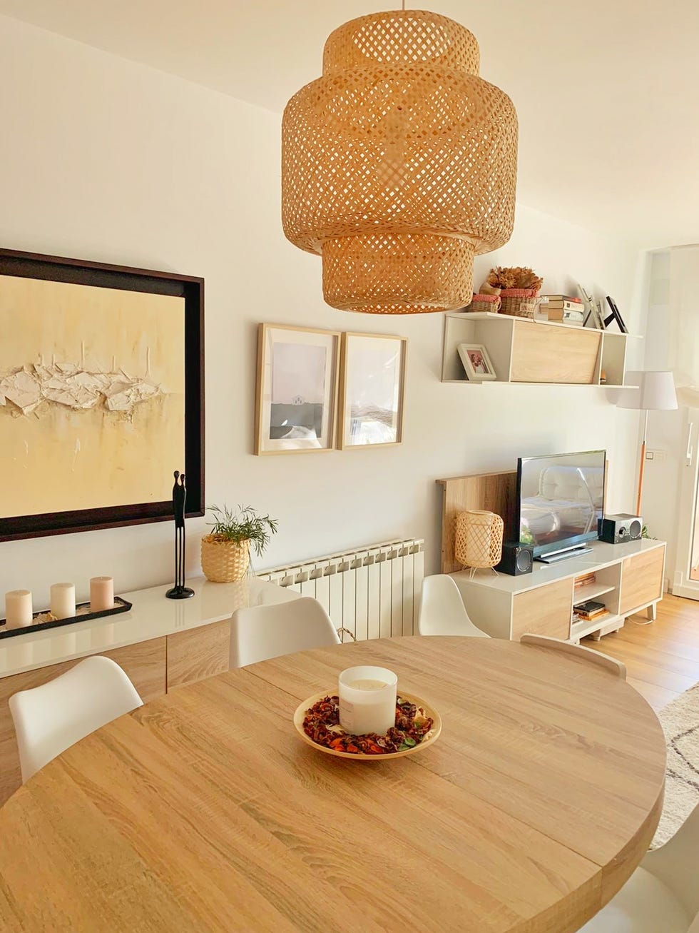 mesa de comedor de madera ovalada, sillas blancas y lámpara de fibras