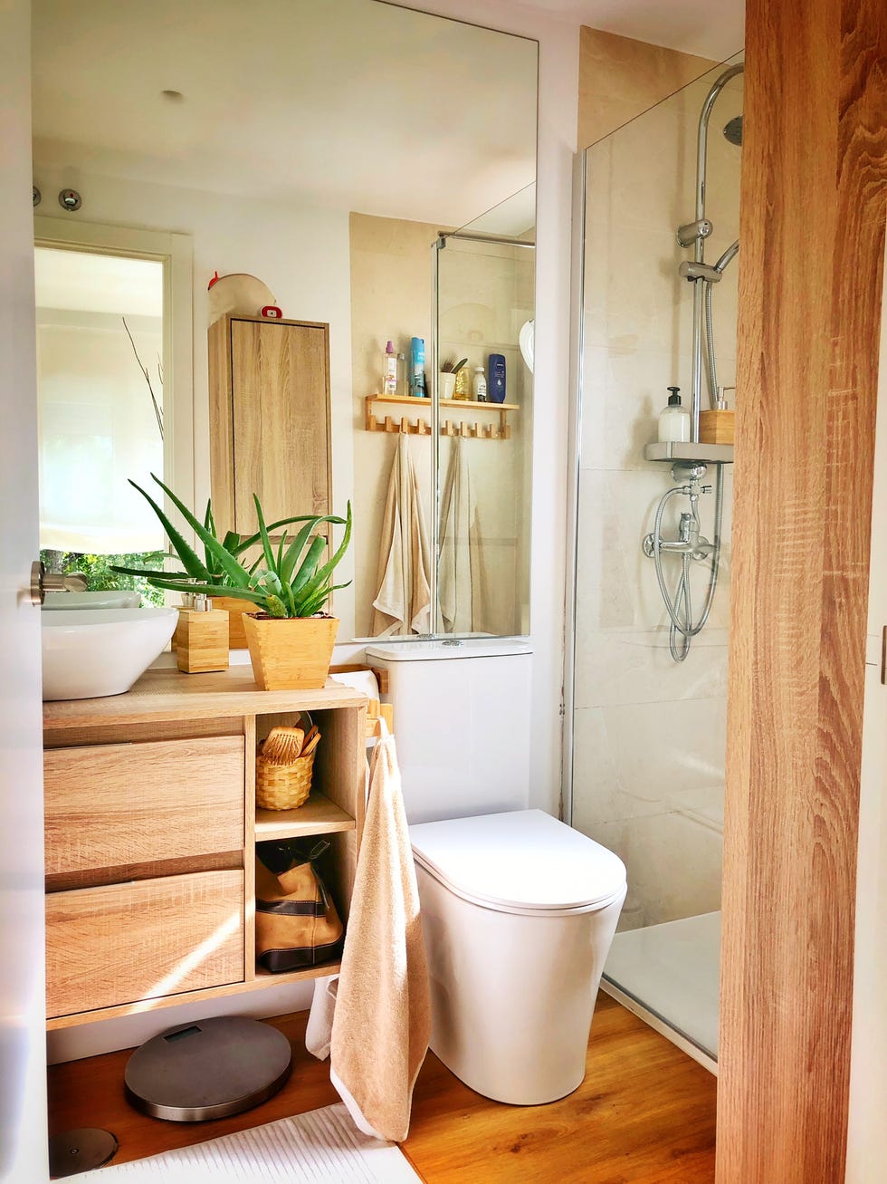 baño con mueble de madera suspendido y ducha a ras de suelo