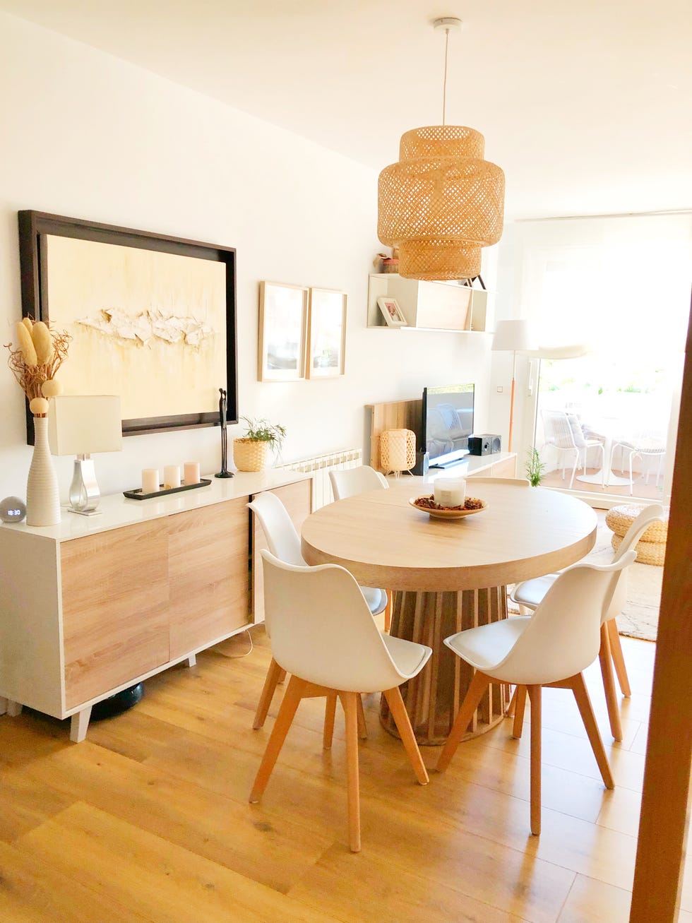 mesa de comedor de madera ovalada, sillas blancas y lámpara de fibras