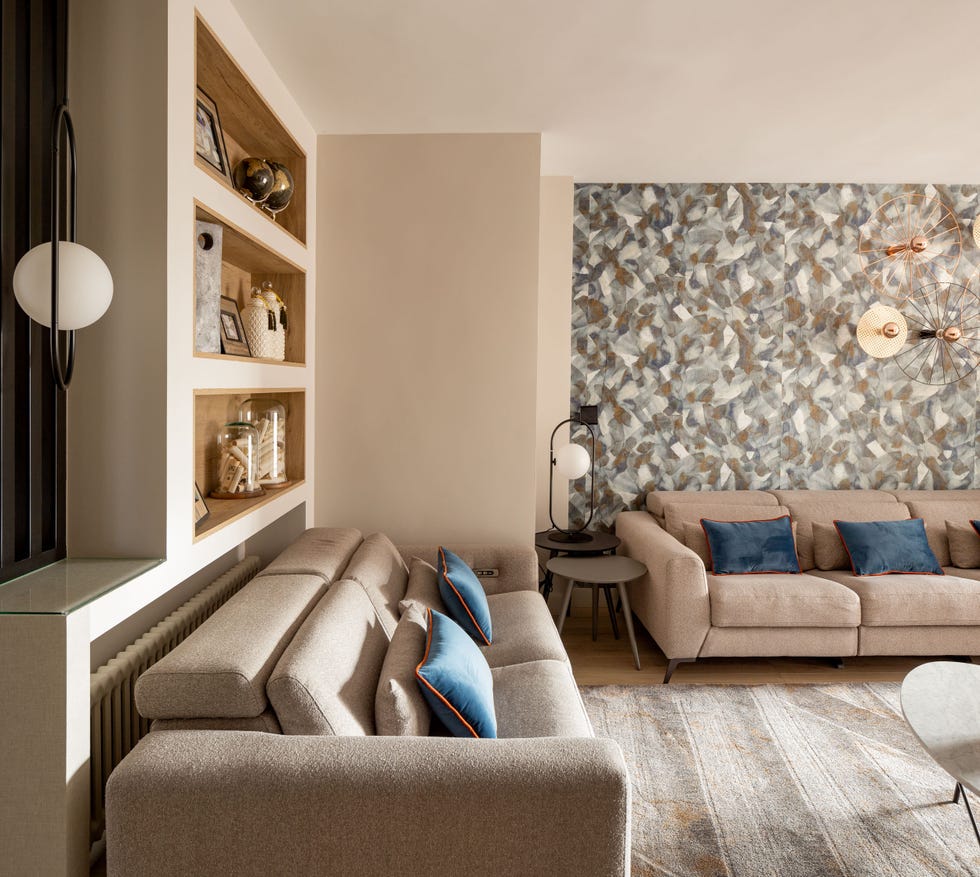 salón moderno con sofás beige y pared con papel pintado
