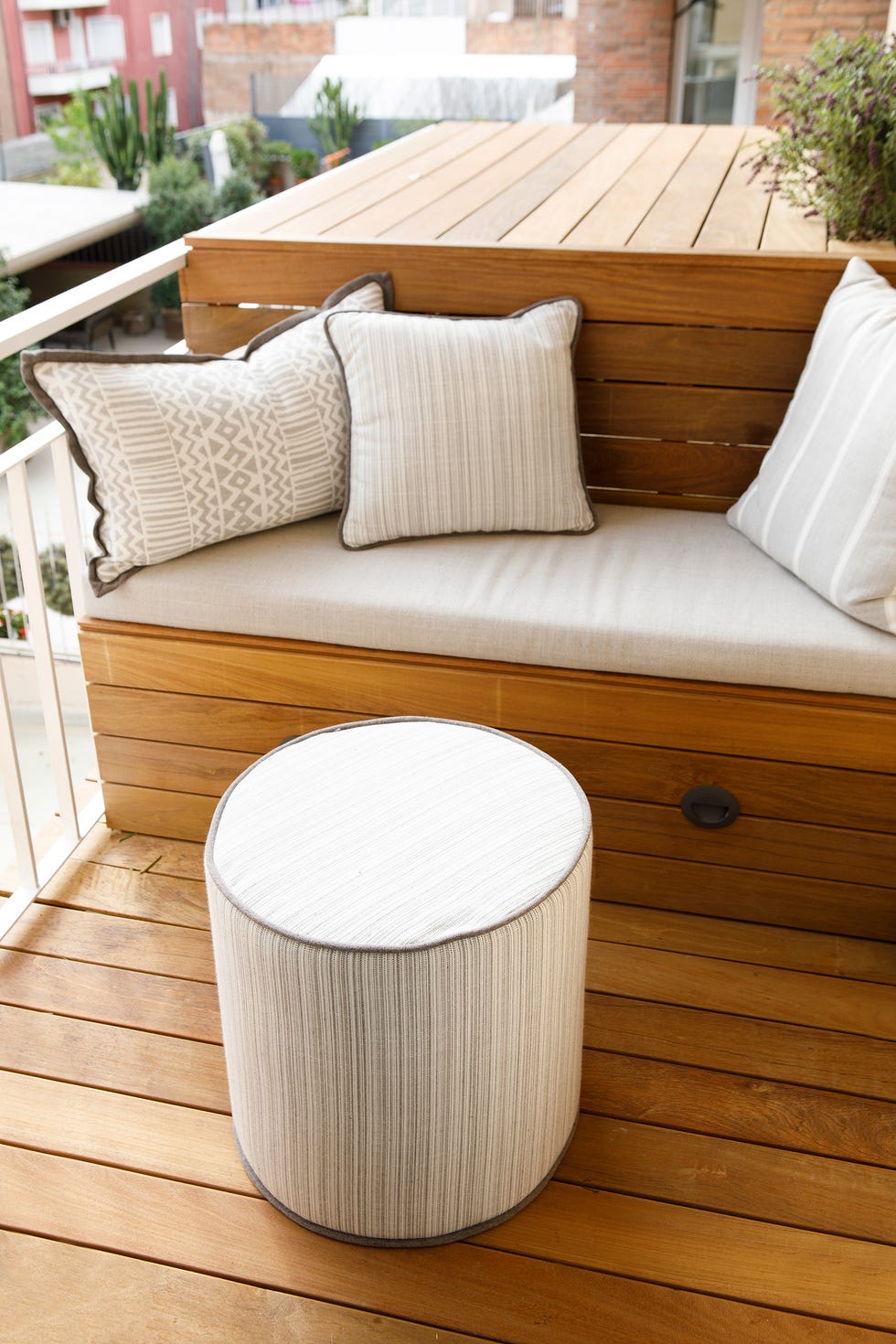 terraza con tarima de madera y cojines en tonos beige