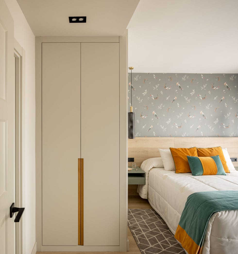 dormitorio con cabecero de madera y papel pintado gris