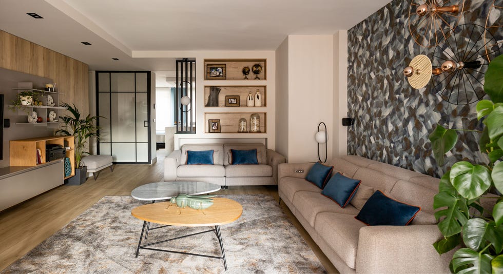 salón moderno con sofás beige y pared con papel pintado