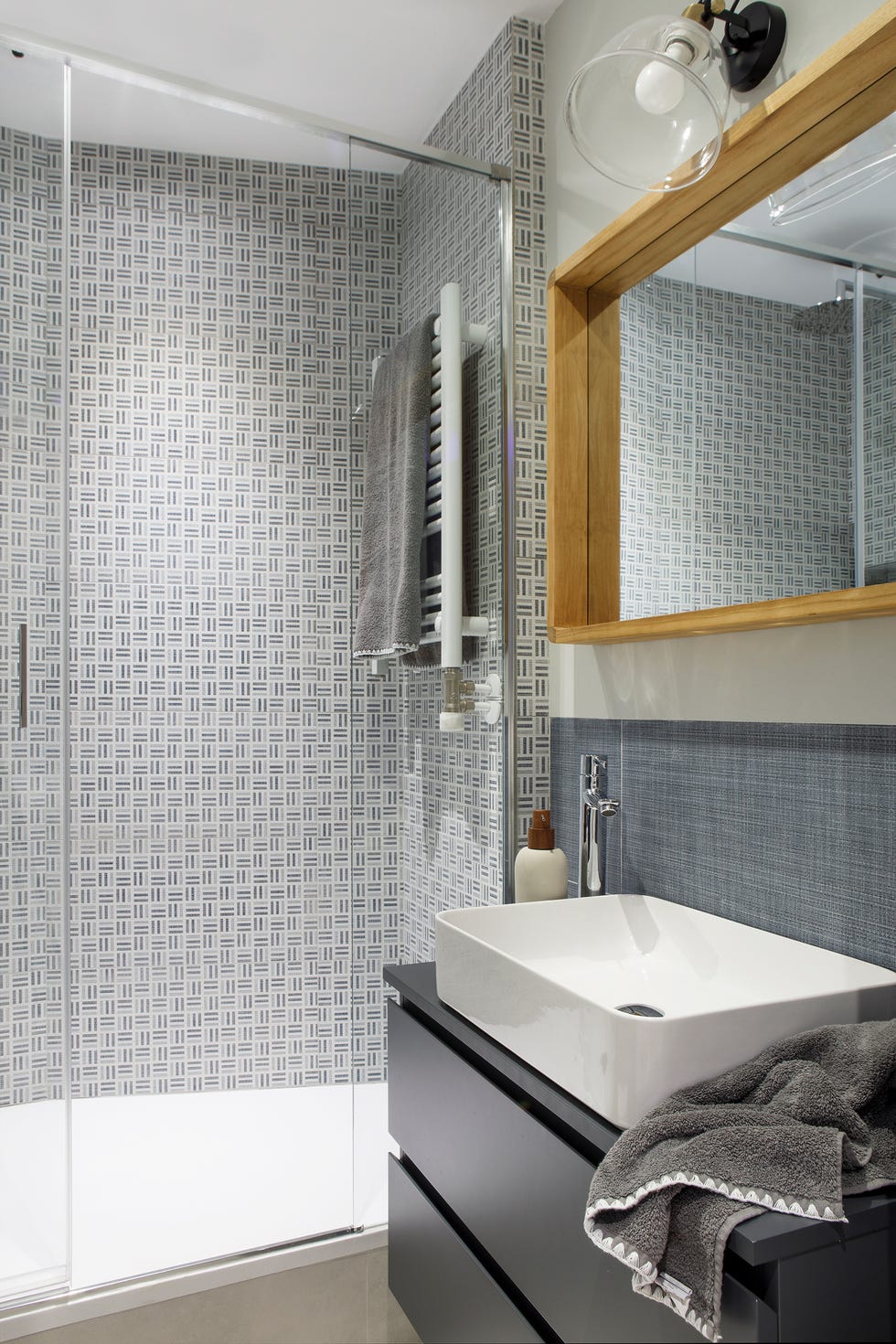 baño con ducha y azulejos con motivos geométricos grises