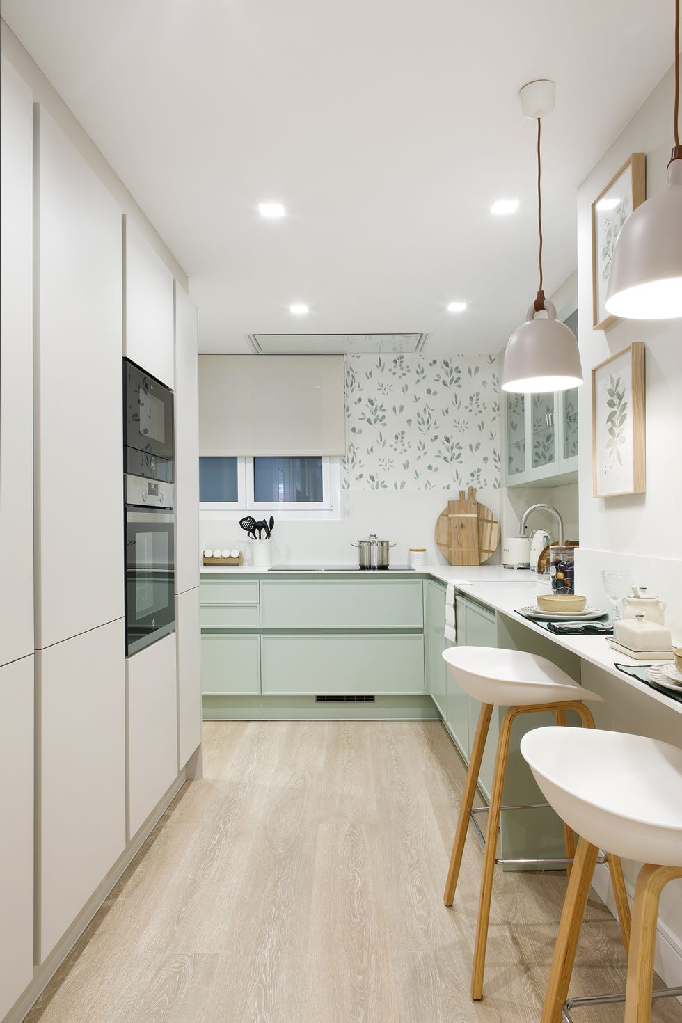 cocina con armario de color verde y papel pintado con motivos botánicos