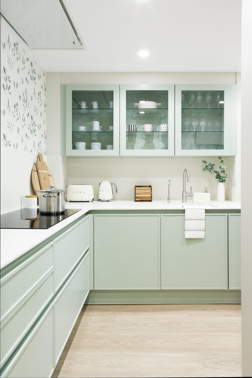 cocina con armario de color verde y papel pintado con motivos botánicos