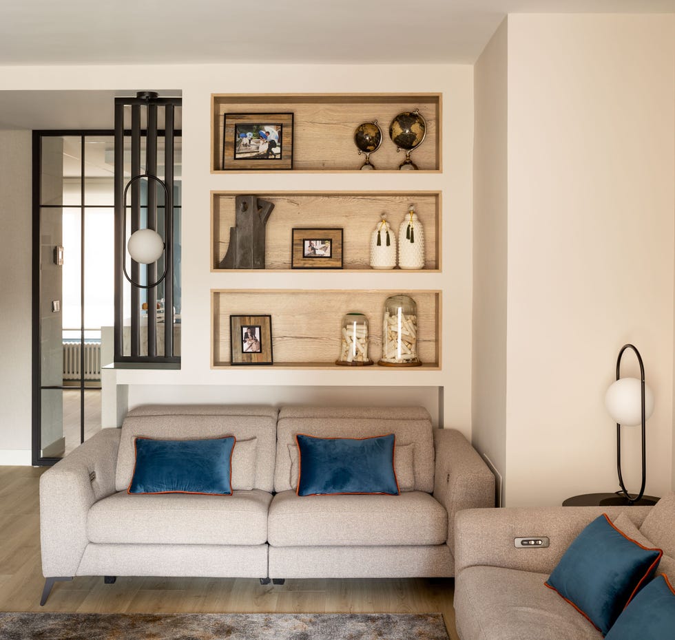 salón moderno con sofás beige y pared con hornacinas de madera