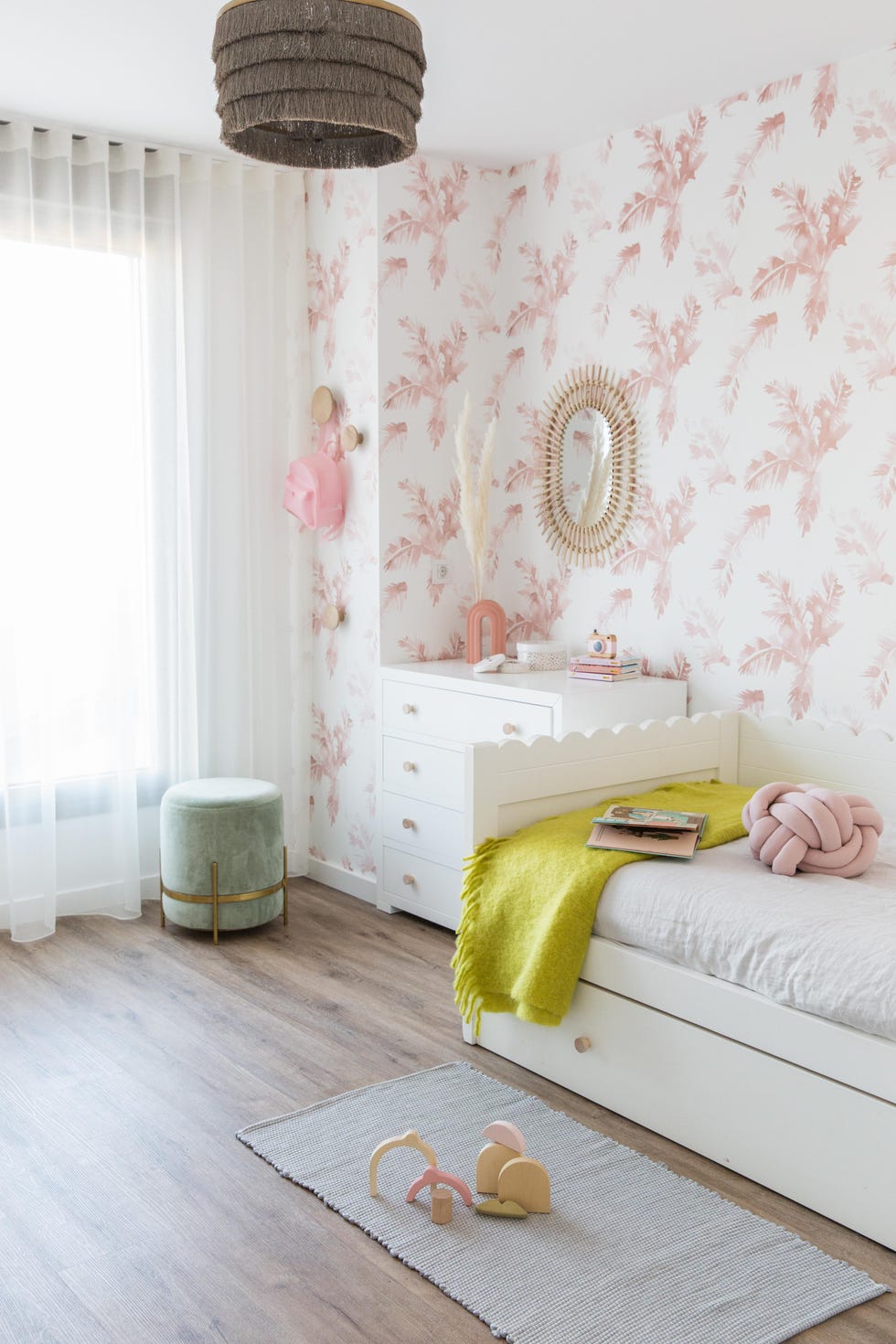 dormitorio infantil con muebles blancos y papel pintado con motivos rosas