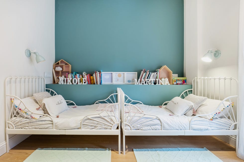 habitación infantil con dos camas de forja blanca