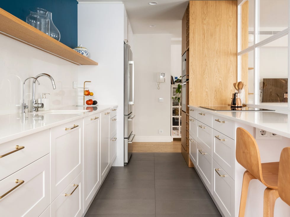cocina blanca con barra y cerramiento acristalado
