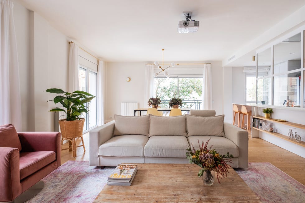 salón abierto com sofá beige y butacas de terciopelo rosa