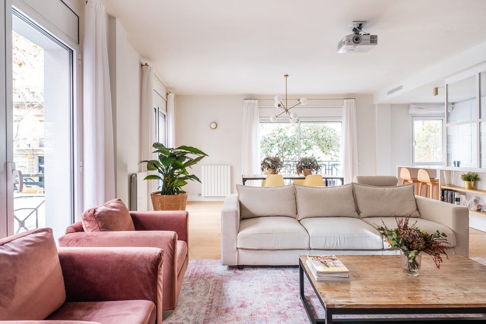 salón abierto con sofá beige y butacas de terciopelo rosa