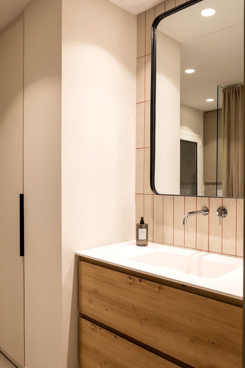 baño con mueble de lavabo de madera y azulejos con las juntas en color caldera