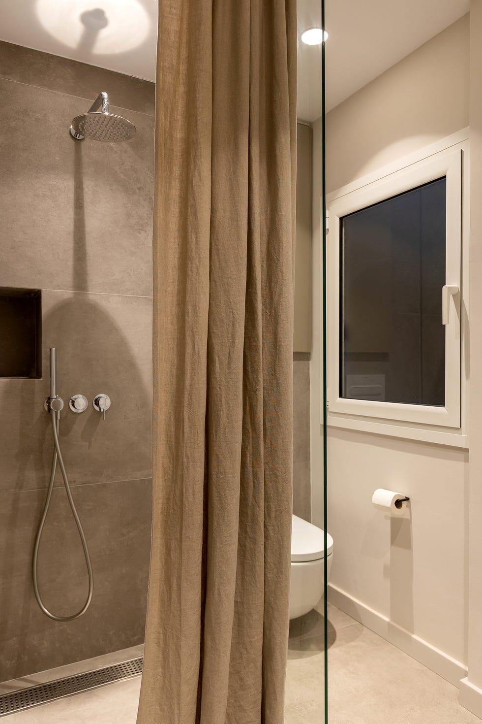 ducha con mampara de cristal y cortinas de lino