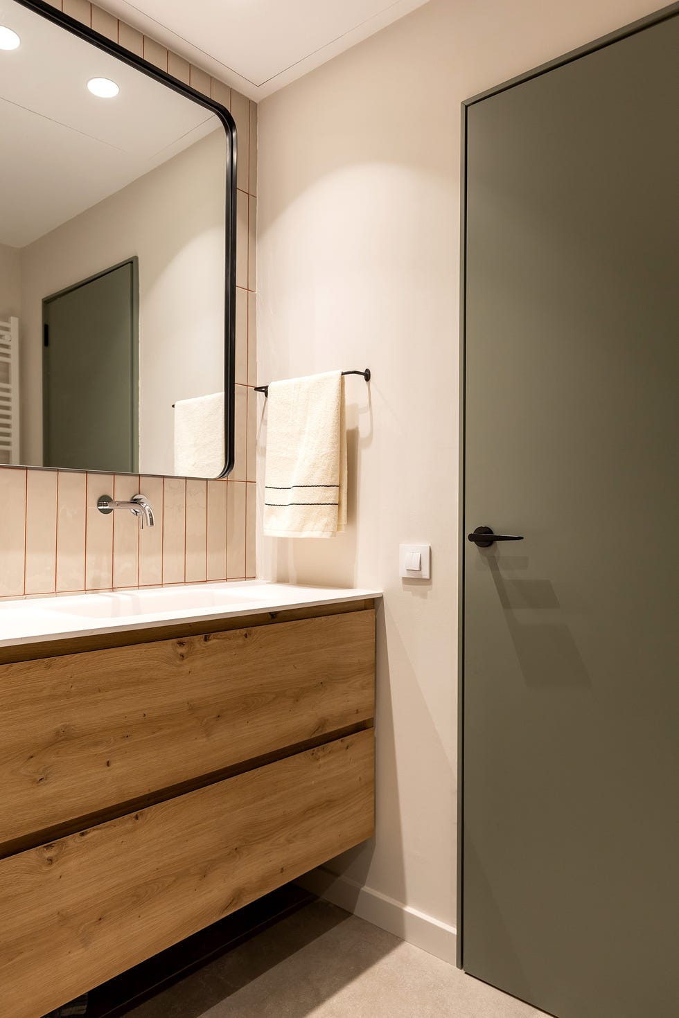 baño con mueble de lavabo de madera y azulejos con las juntas en color caldera