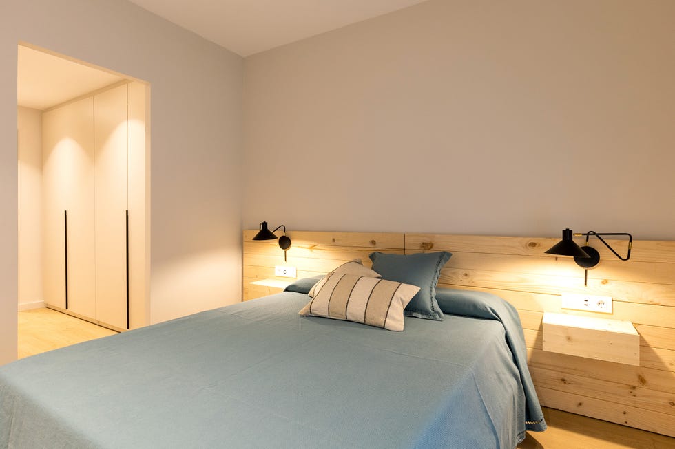 dormitorio con cabecero de madera y vestidor en suite