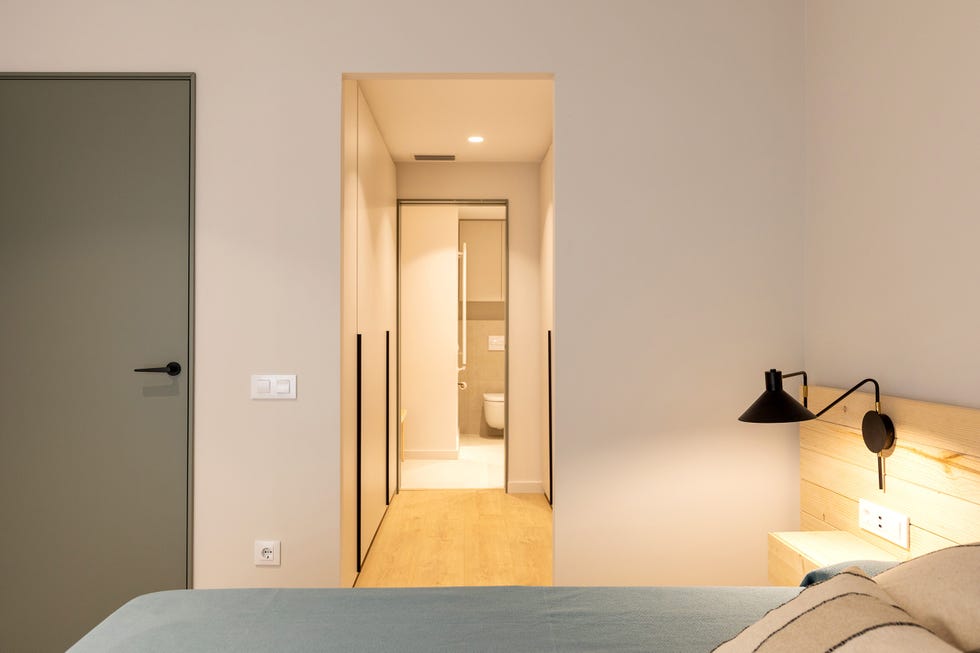 dormitorio con cabecero de madera y vestidor en suite