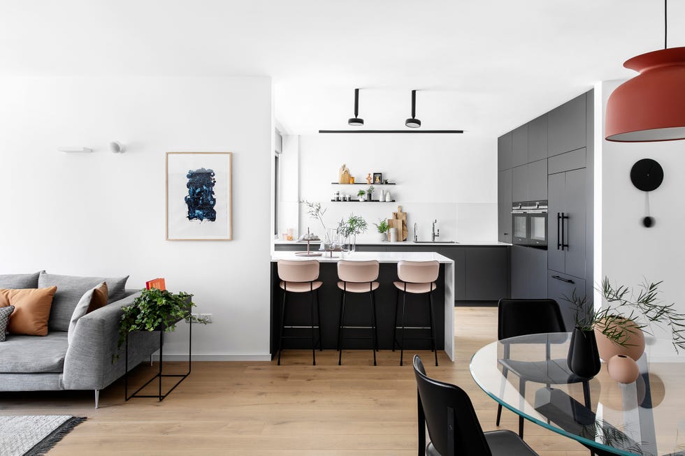 cocina abierta con península de mármol y taburetes de piel rosa