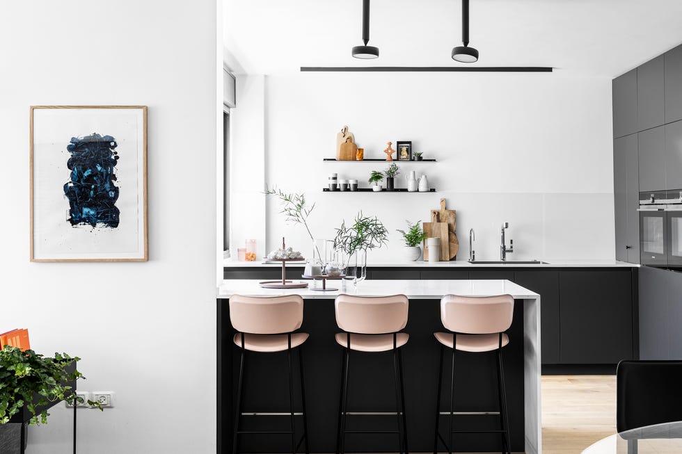 cocina abierta con península de mármol y taburetes de piel rosa