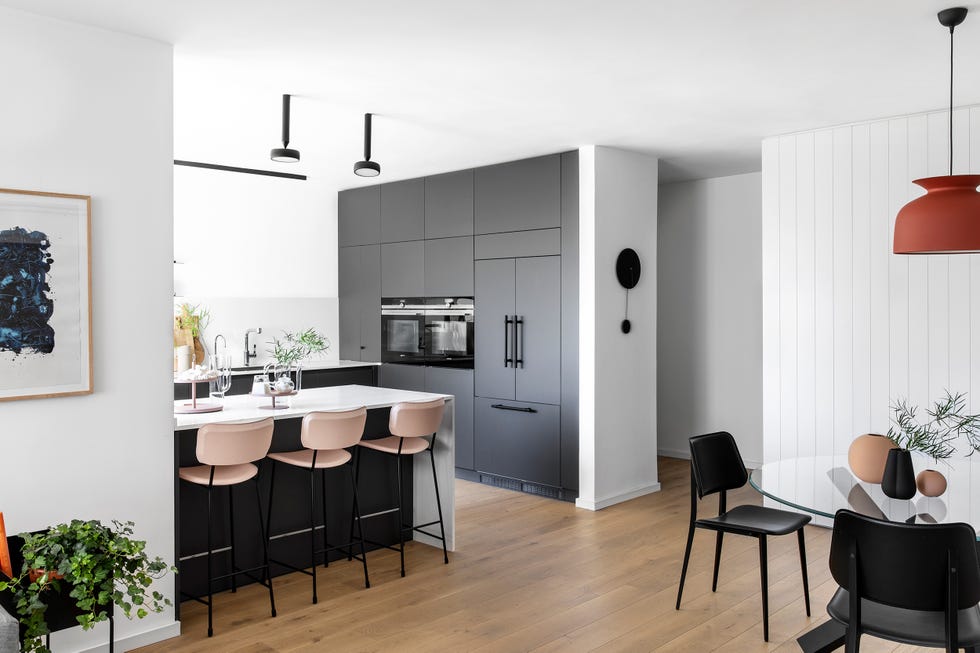 cocina abierta con península diseñada en blanco y gris oscuro