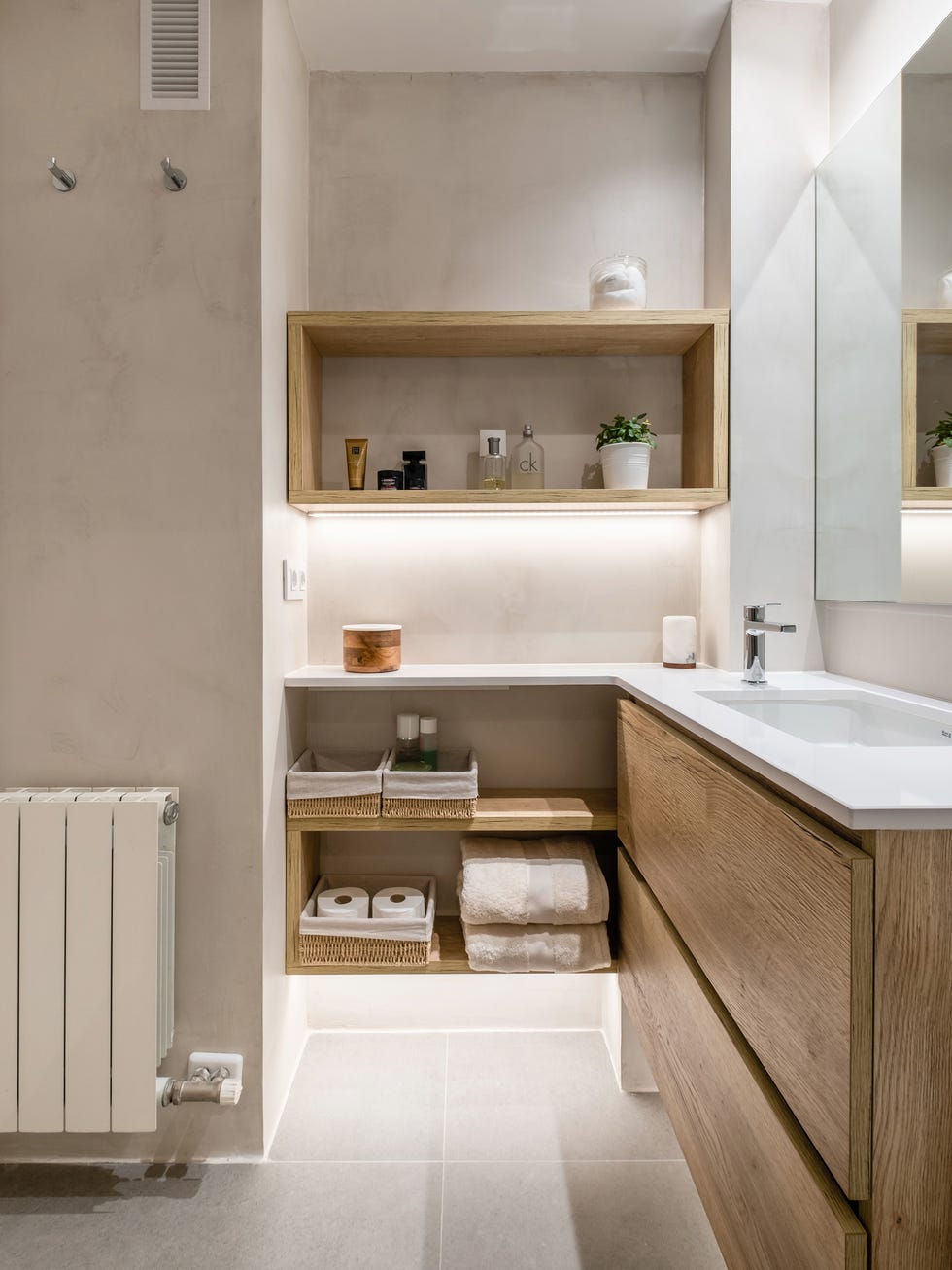 baño con mueble de madera en l suspendido y encimera blanca