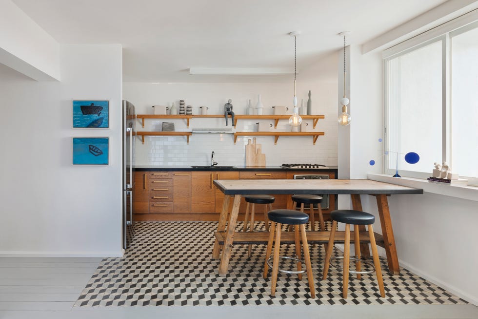 cocina abierta moderna con office y muebles de madera y baldosas geométricas en el suelo