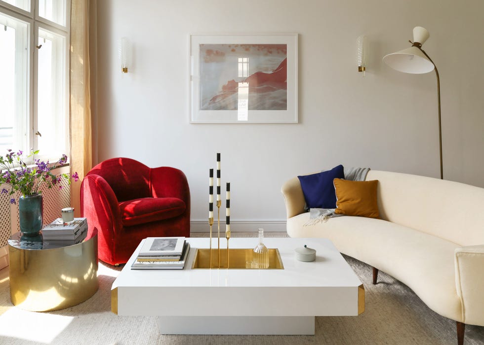 salón de diseño contemporáneo con sofá beige y butaca roja de terciopelo