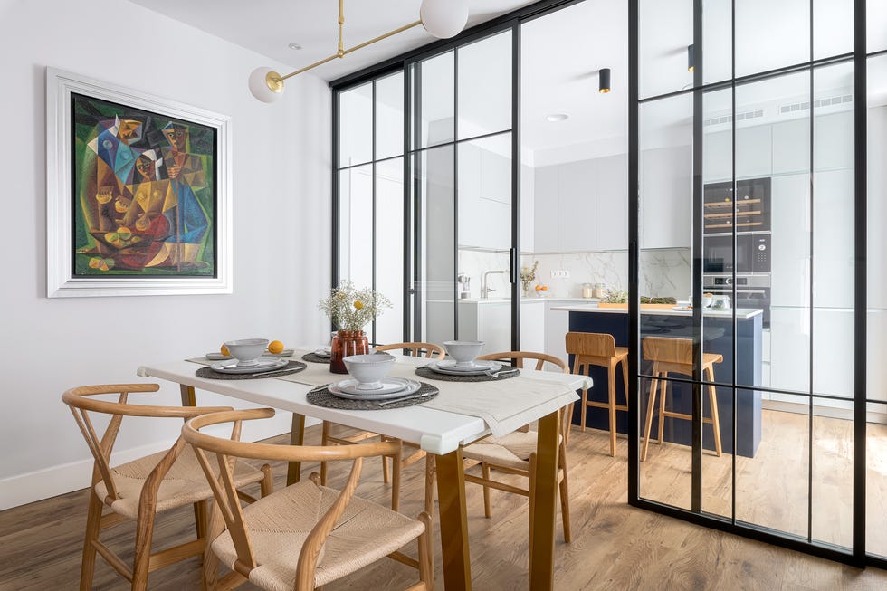 cocina integrada en el salón con cerramiento de cristal y perfilería metálica negra