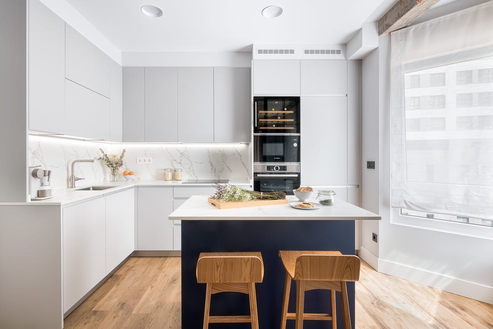 cocina moderna con isla central revestida en color azul y armarios sin tiradores