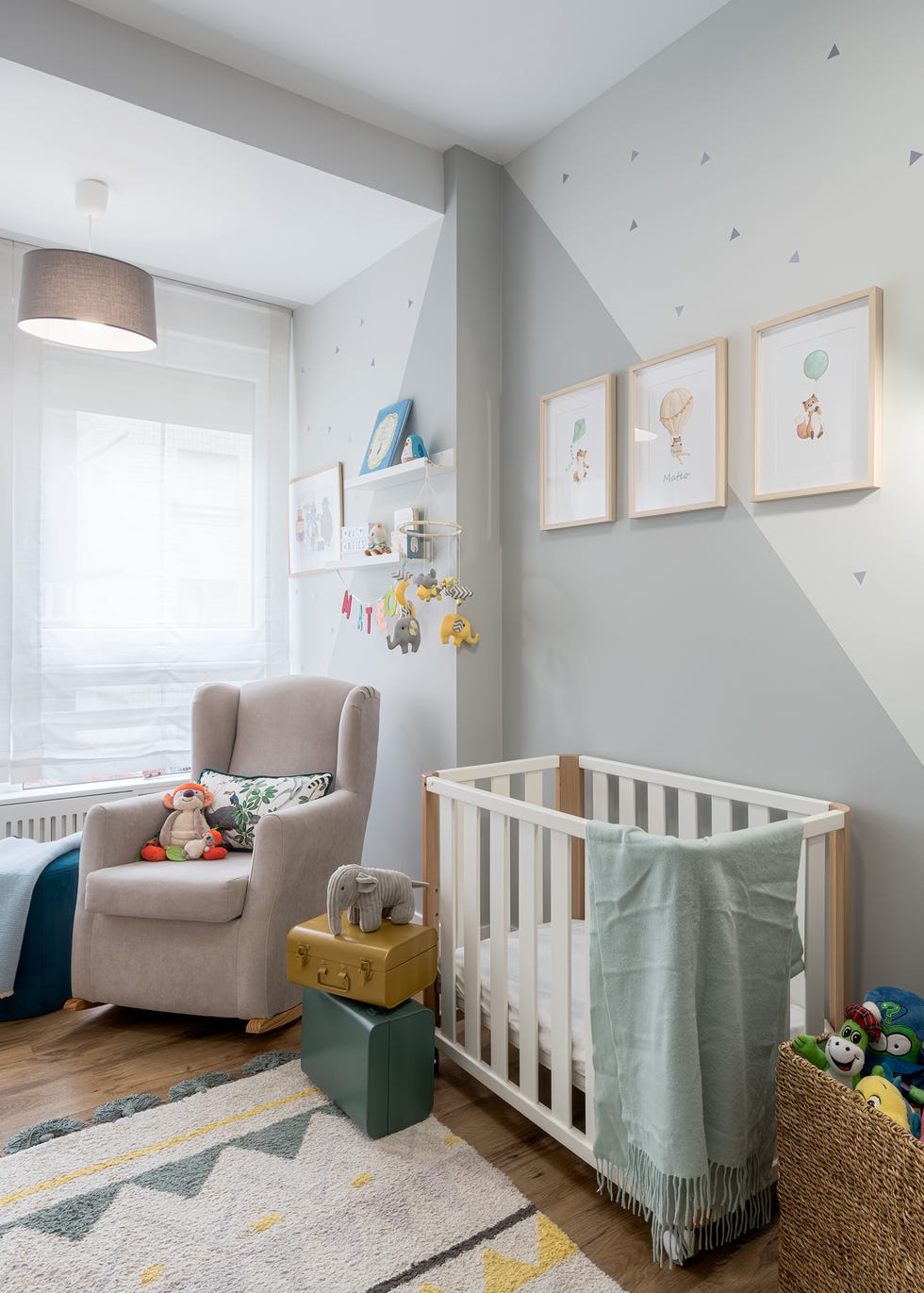 habitación infantil nórdica con cuna y butaca de lectura