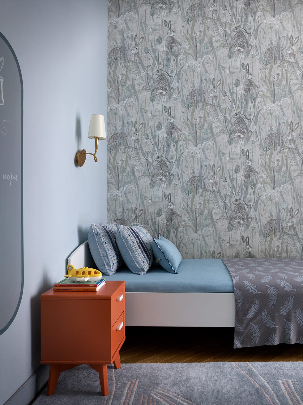 habitación infantil decorada con papel pintado de fauna y flora en tonos grises y azules