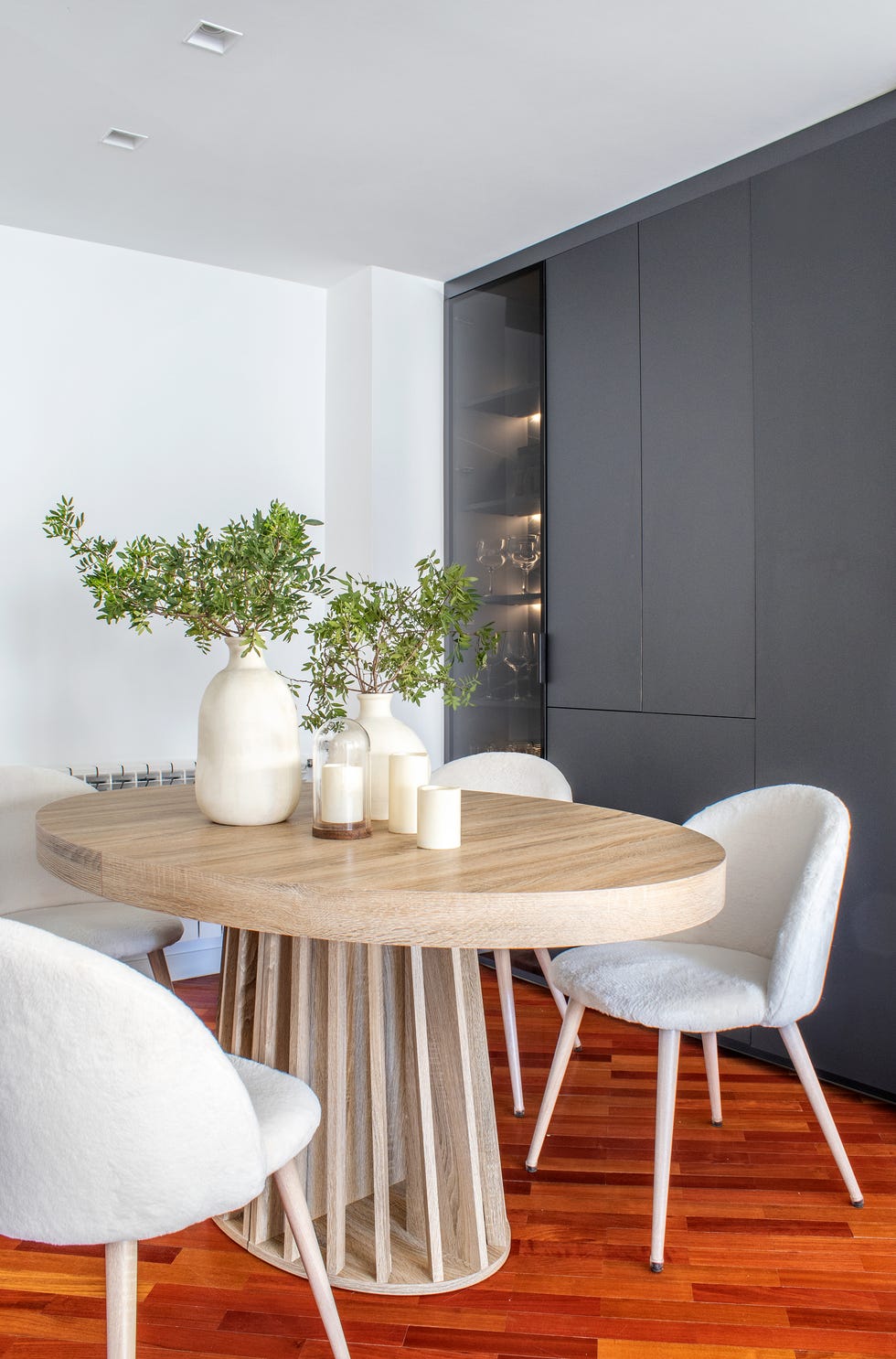 comedor moderno con mesa de madera y sillas nórdicas de pelo blanco