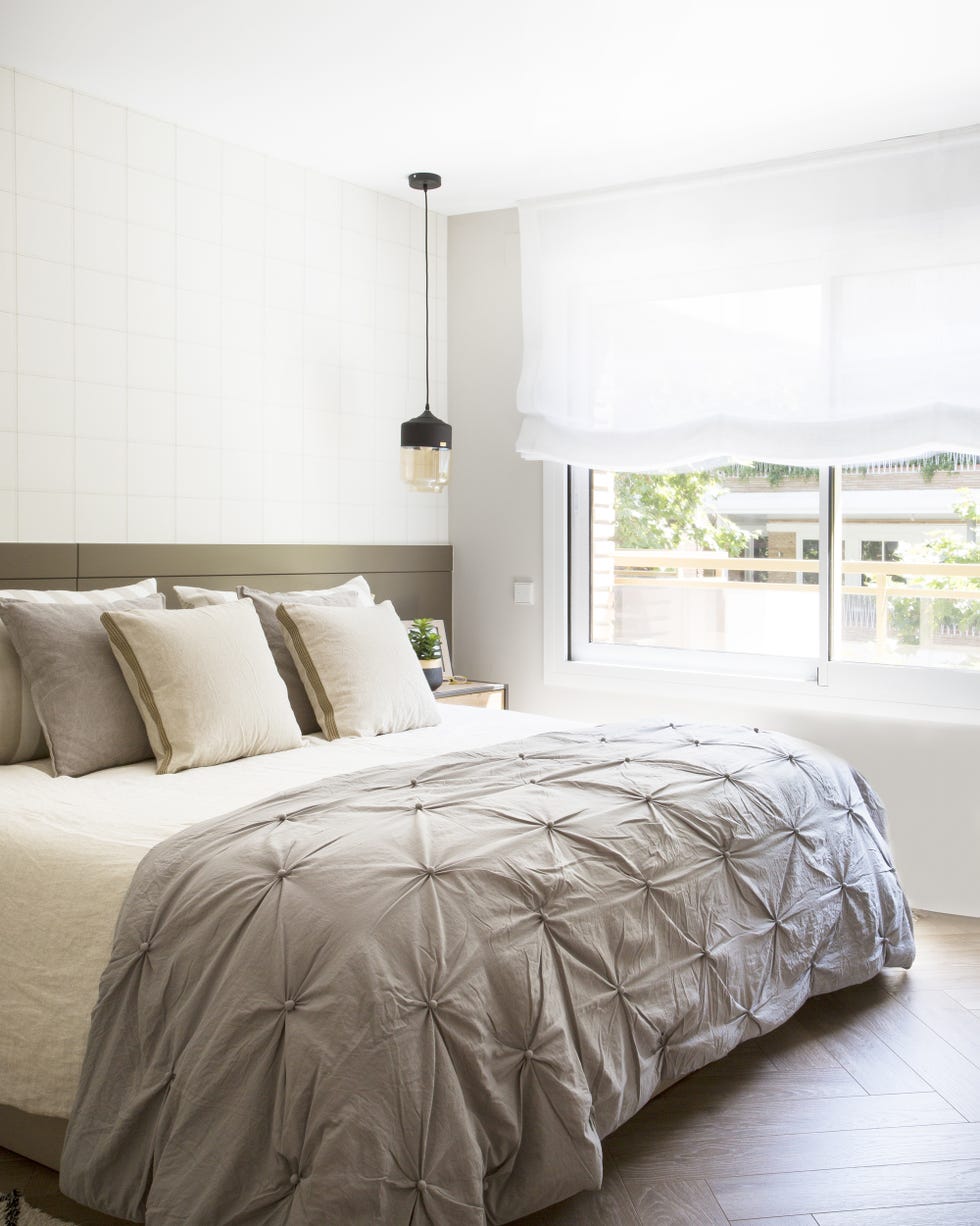 dormitorio decorado en tonos neutros con cabecero a medida