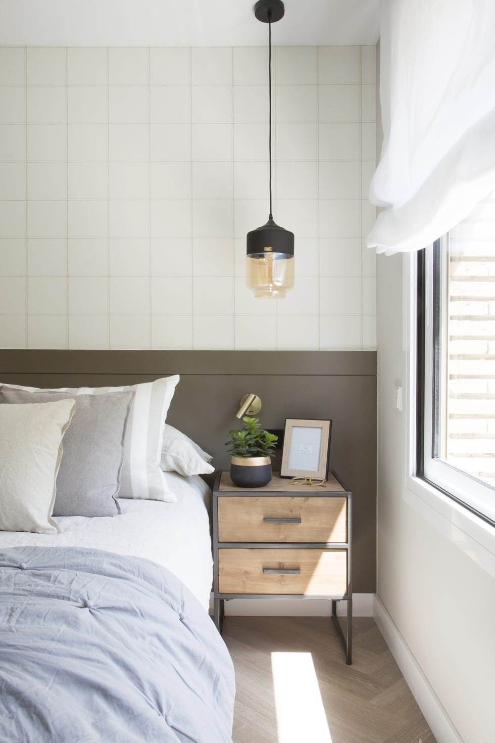 dormitorio decorado en tonos neutros con cabecero a medida y mesita de estilo industrial