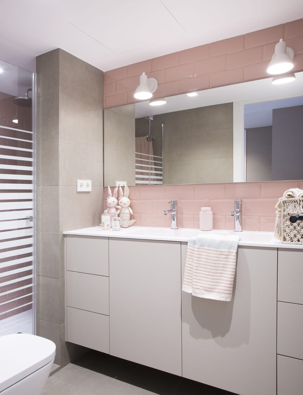 baño infantil moderno con azulejos tipo metro rosas y mueble suspendido