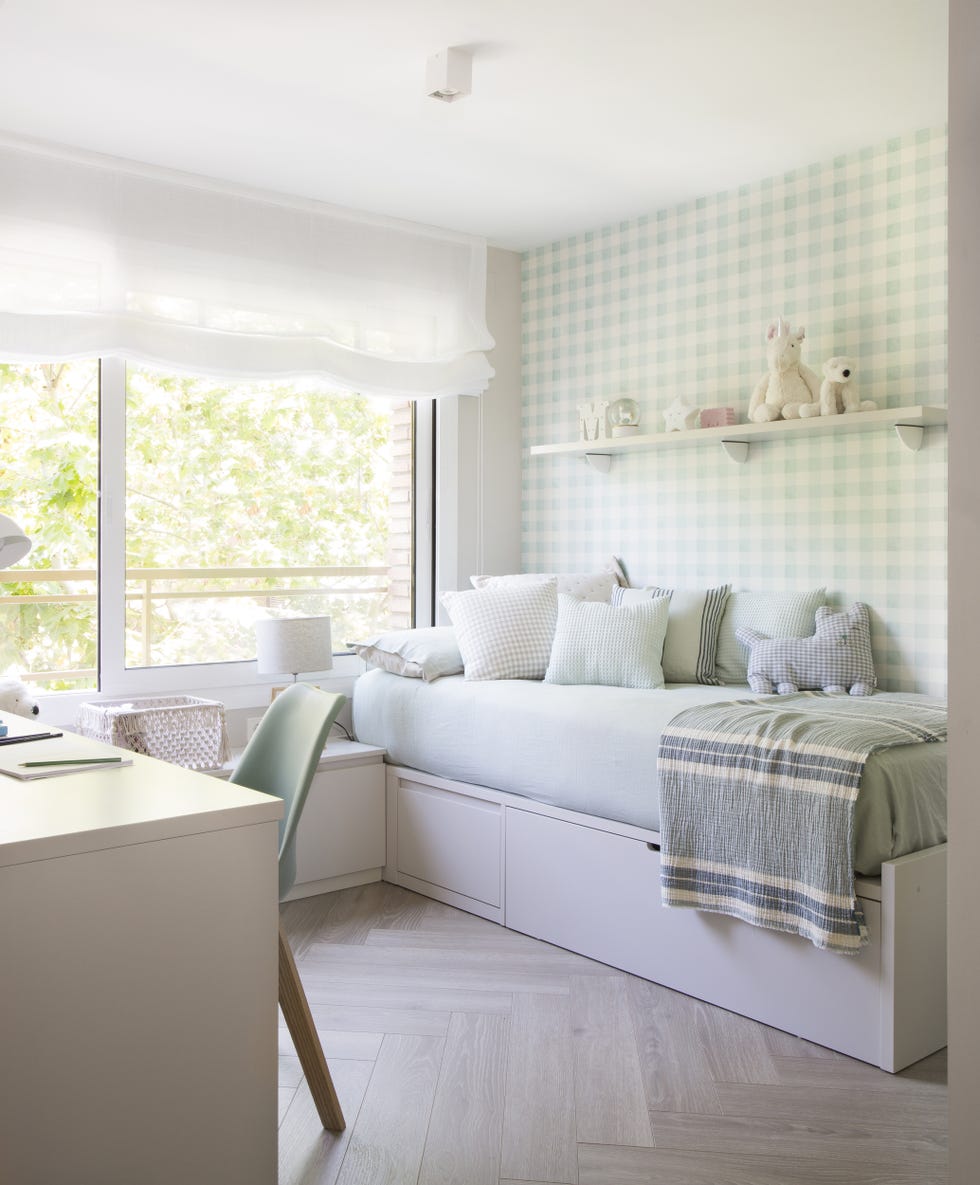 habitación infantil con cama nido, escritorio y papel pintado de cuadros verdes