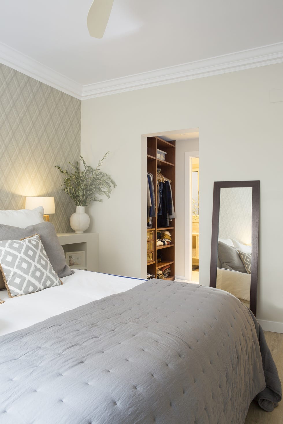 dormitorio decorado en tonos neutros con vestidor y baño en suite