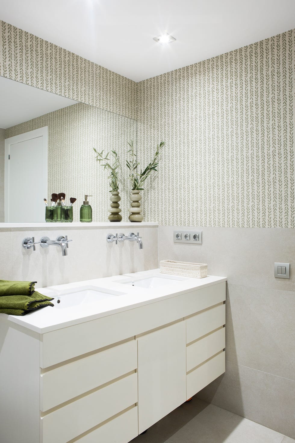 baño con mueble blanco suspendido y papel pintado