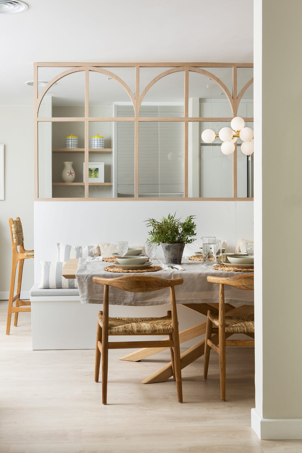 comedor con banco de obra, sillas de madera y biombo que lo separa de la cocina