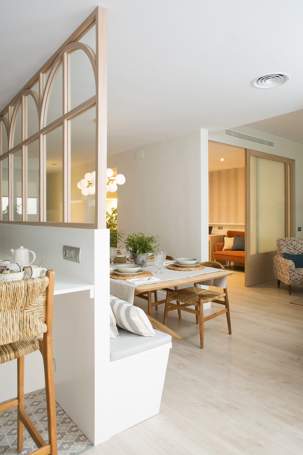 comedor con banco de obra, sillas de madera y biombo que lo separa de la cocina