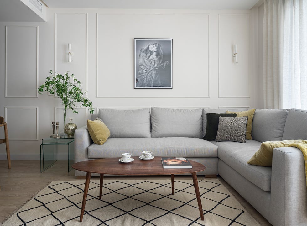 salón abierto con sofá esquinero tapizado en color gris