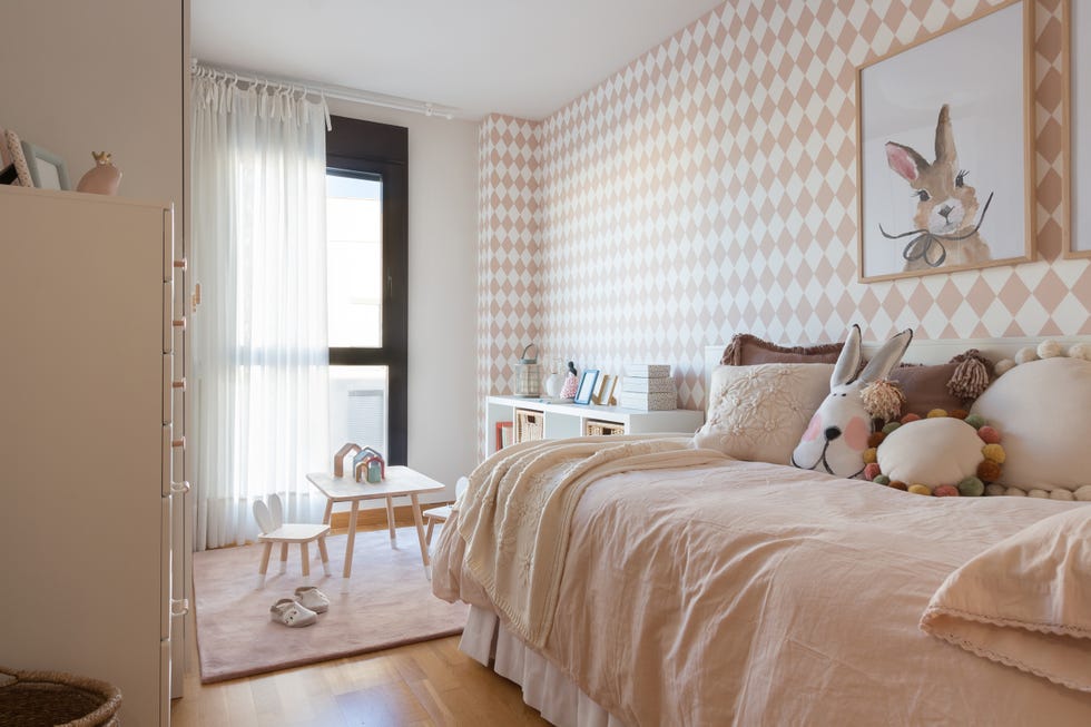 habitación infantil con muebles blancos y papel pintado con rombos rosas