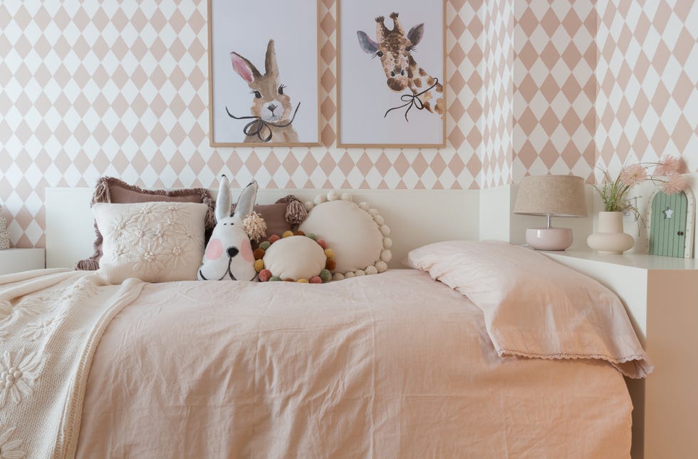 habitación infantil con muebles blancos y papel pintado con rombos rosas