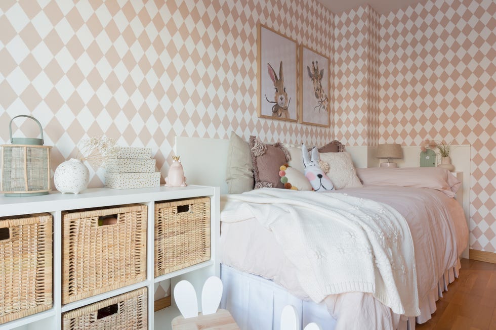 habitación infantil con muebles blancos y papel pintado con rombos rosas