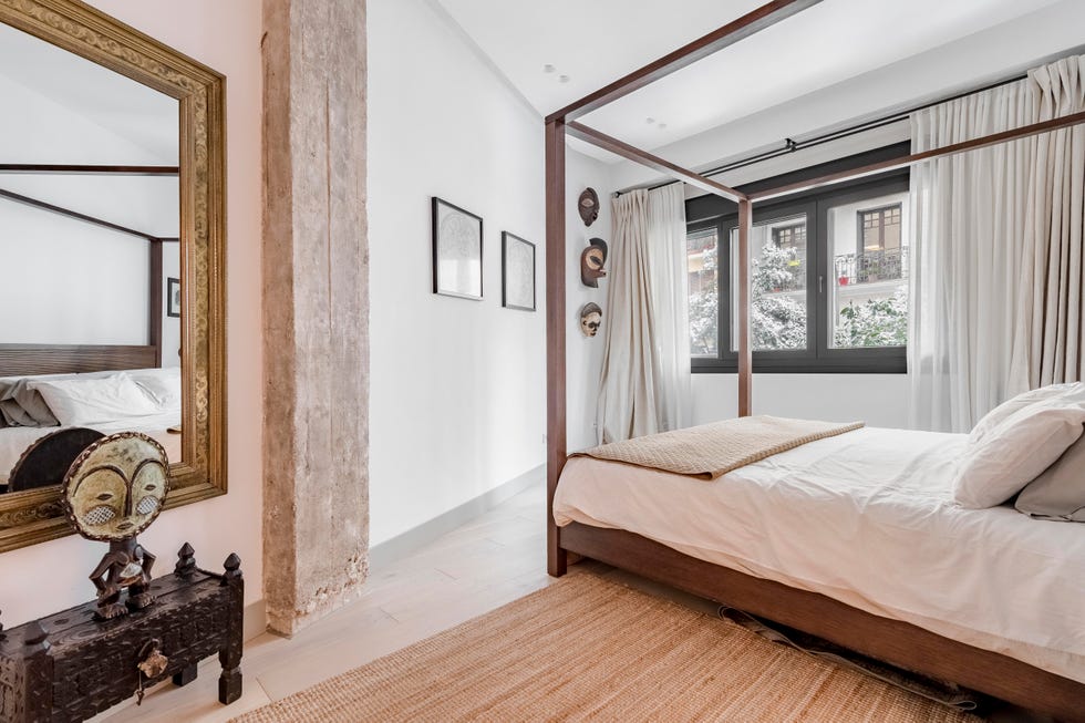 dormitorio con cama con dosel de madera y decoración exótica