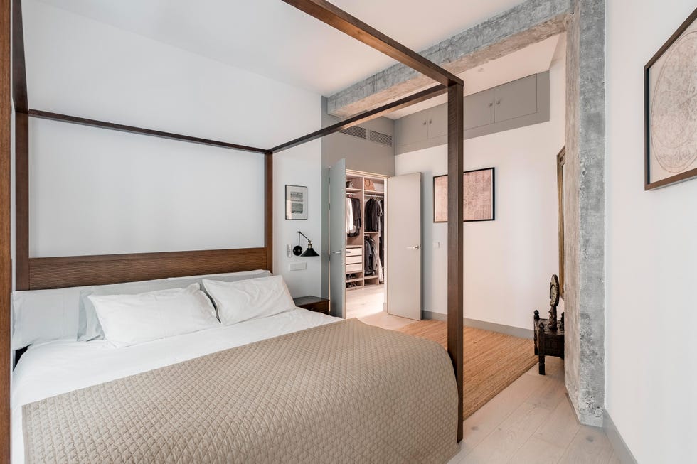 dormitorio con cama con dosel de madera, decoración exótica y acceso al vestidor
