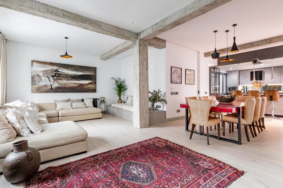 salón abierto al comedor y a la cocina con vigas y columnas vistas de cemento