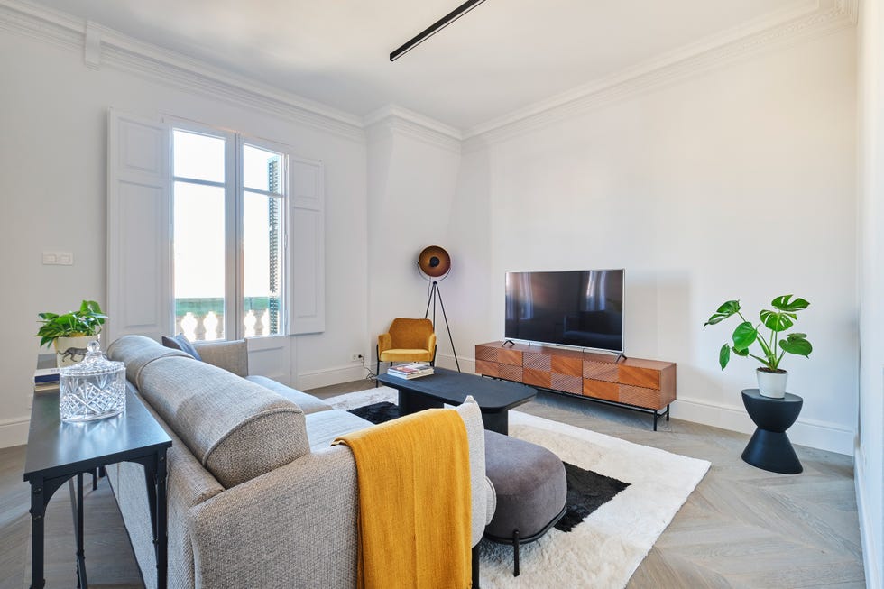salón con sofá gris y mueble de tv de madera