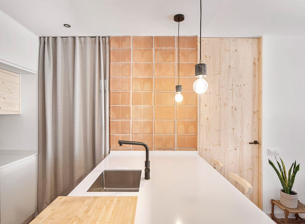 cocina con barra de color blanco y revestimientos de ladrillo visto