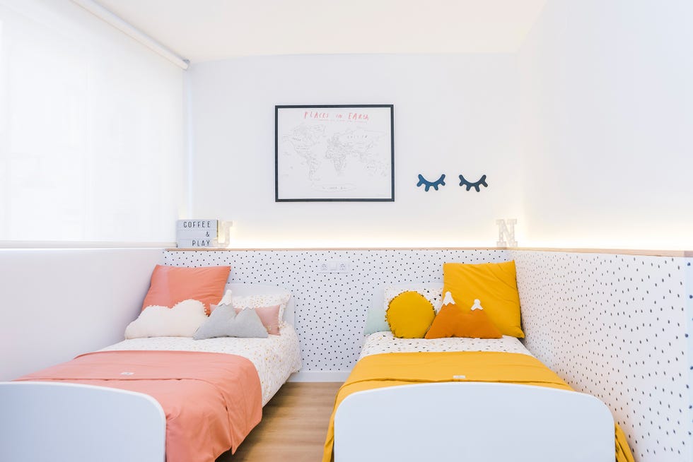 dormitorio infantil de estilo nórdico con dos camas y papel pintado de puntitos